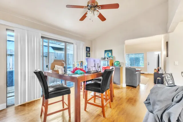 a kitchen with stainless steel appliances granite countertop a refrigerator a stove a microwave oven with a dining table and chairs with wooden floor