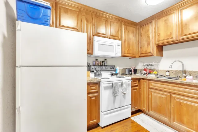 a kitchen with stainless steel appliances granite countertop a sink a stove and refrigerator