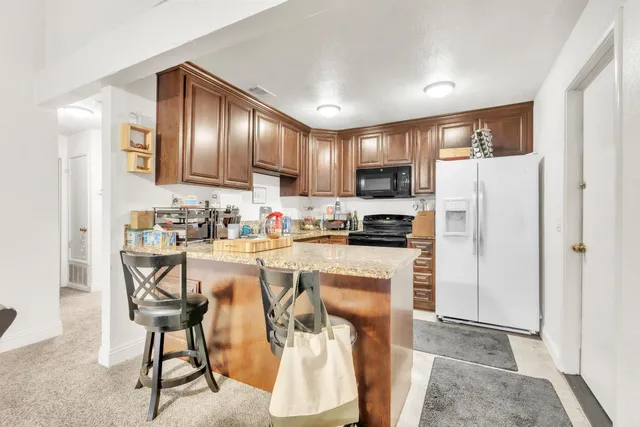 a kitchen with stainless steel appliances granite countertop a refrigerator and a stove top oven