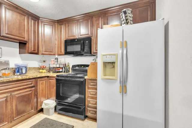 a kitchen with a refrigerator sink and cabinets