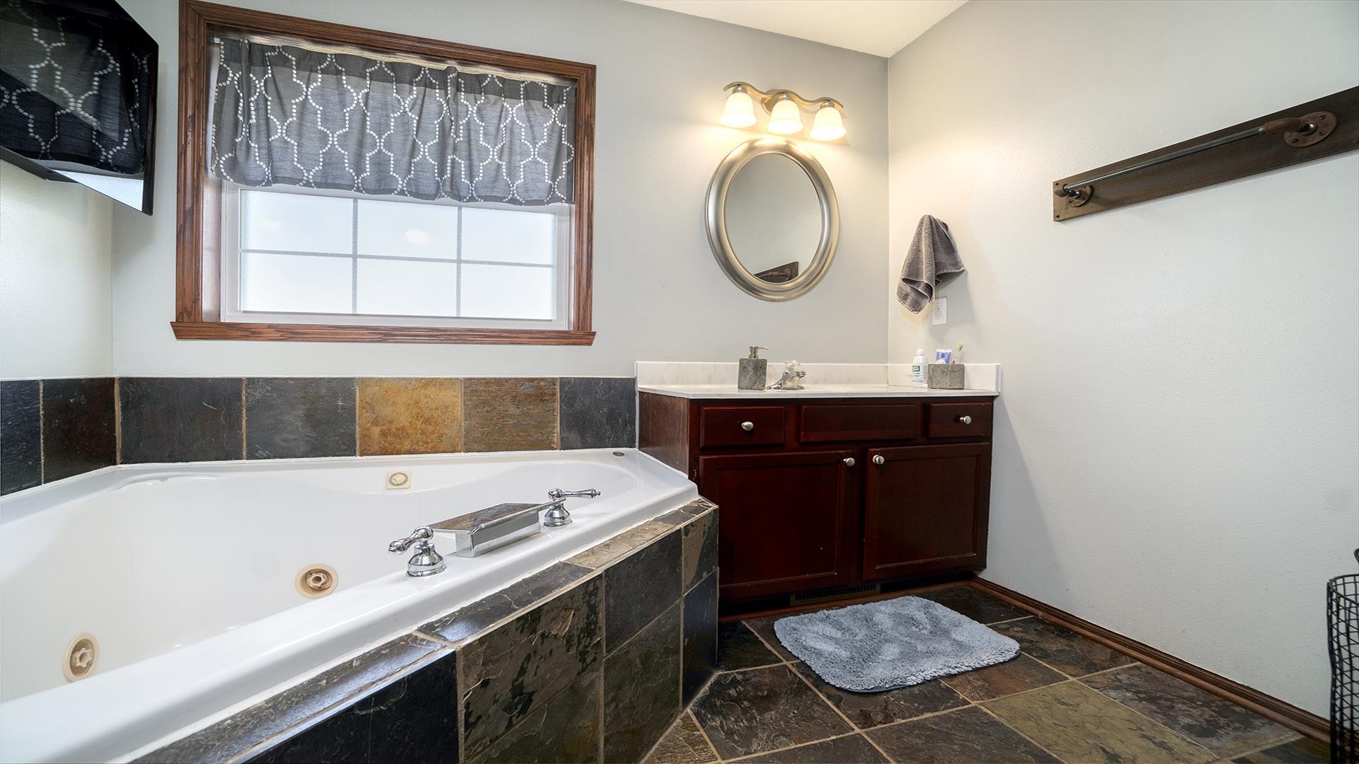 5108 North Winnebago Road Winnebago, IL 61088 - Photo 17 of 50 a bathroom with a tub sink and mirror