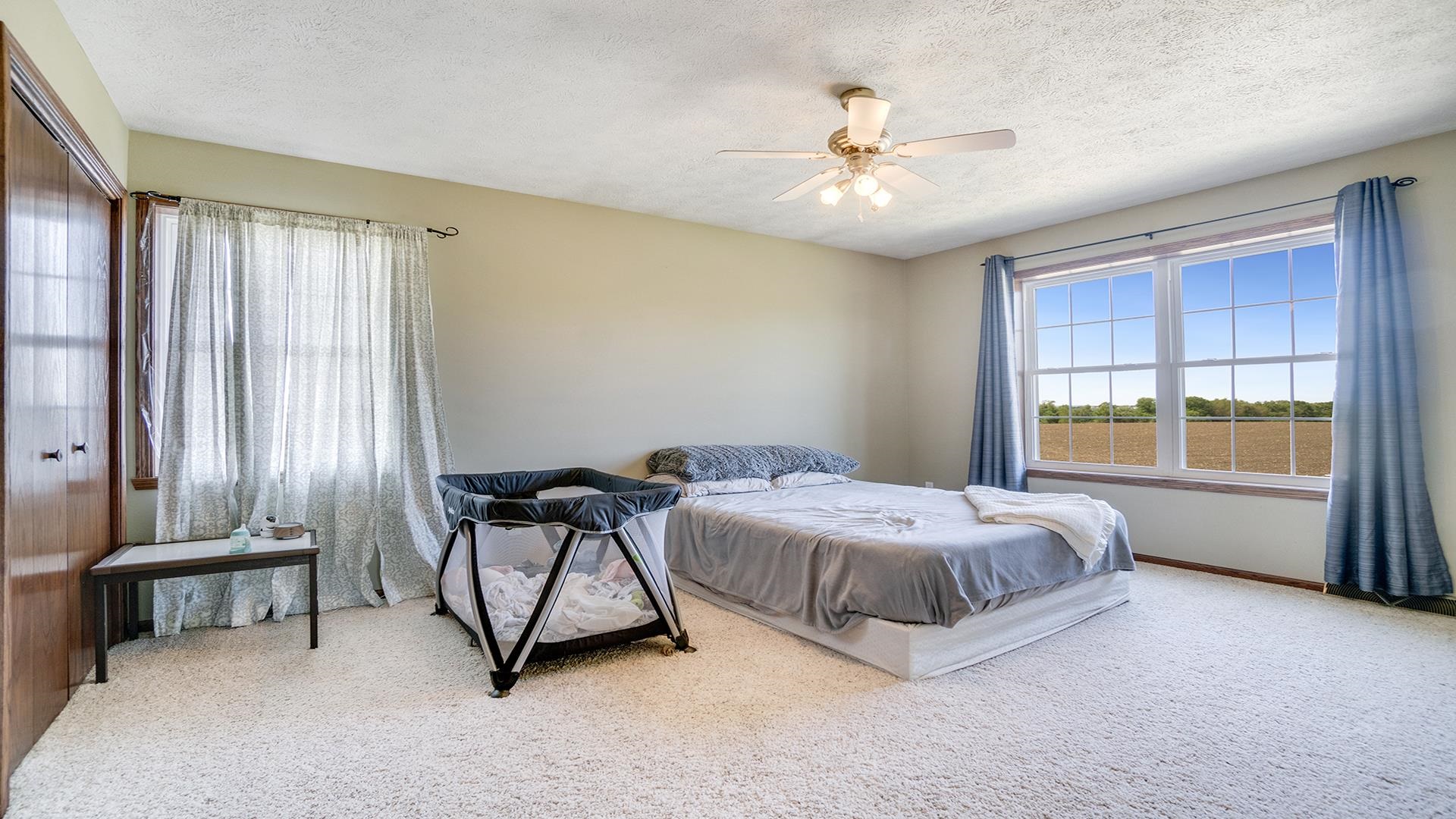 5108 North Winnebago Road Winnebago, IL 61088 - Photo 22 of 50 a spacious bedroom with a bed and a chandelier