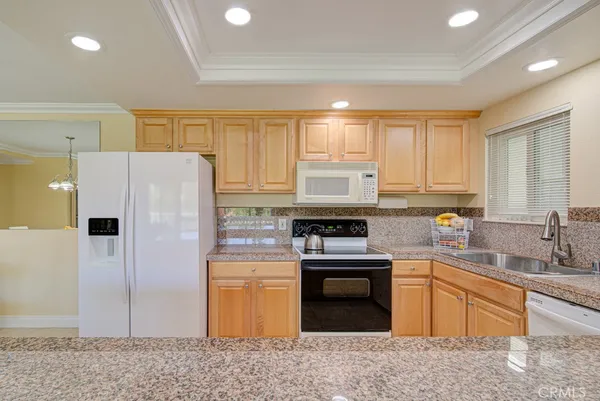 a kitchen with stainless steel appliances granite countertop a stove a sink dishwasher a refrigerator and a microwave