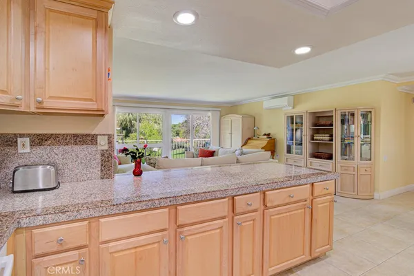 a kitchen with granite countertop a sink and white cabinets