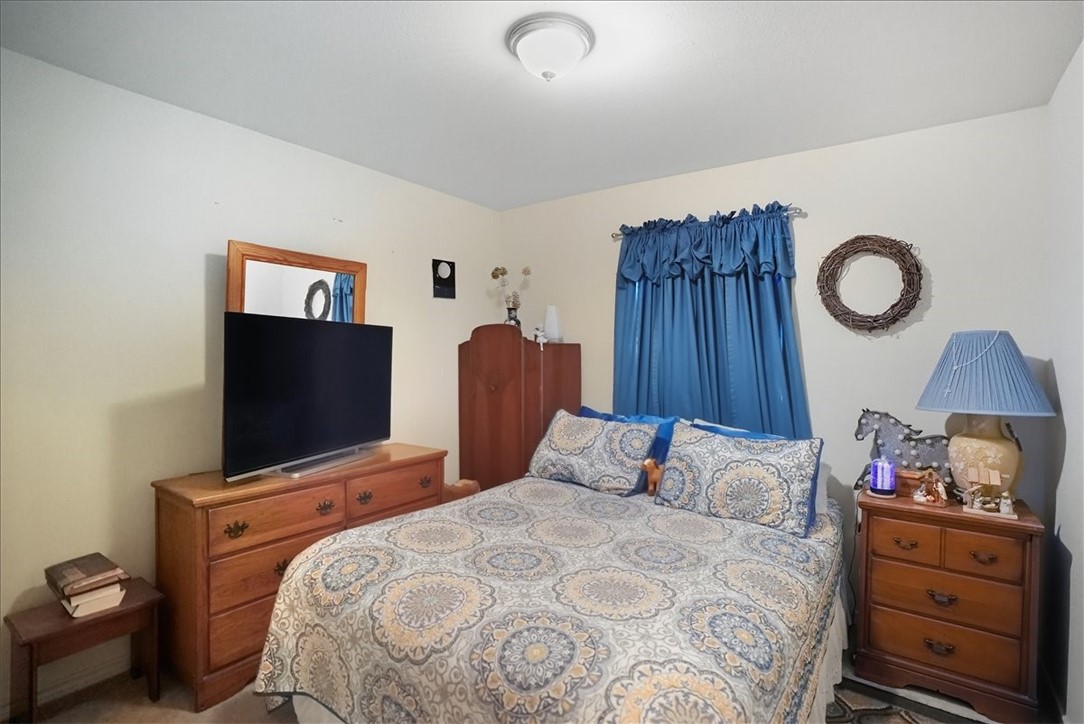 3260 Highway 281 George West, TX 78022 - Photo 14 of 34 a bedroom with a bed and a flat tv screen on dresser