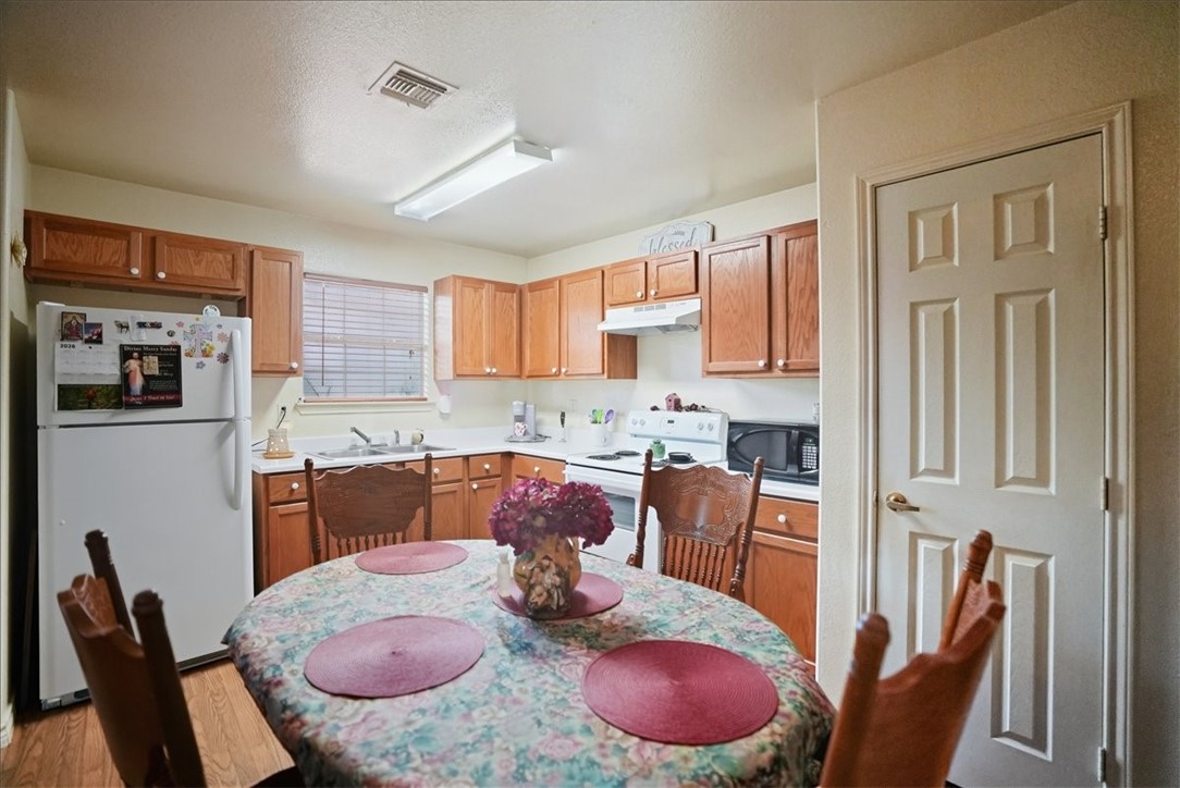 3260 Highway 281 George West, TX 78022 - Photo 6 of 34 a kitchen with stainless steel appliances granite countertop a stove a sink a dining table and chairs