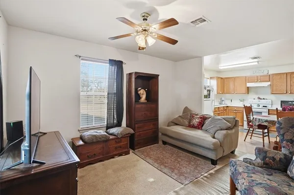 a living room with furniture ceiling fan and a window