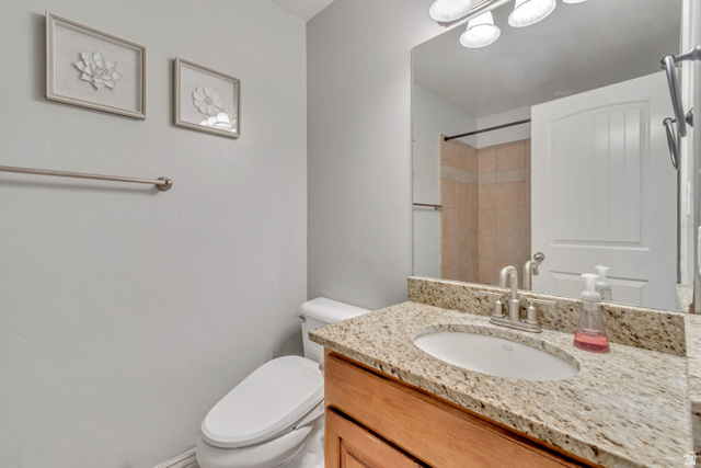 356 North 230 West Payson, UT 84651 - Photo 22 of 45 Bathroom featuring a granite countertop vanity with an undermount sink, a large wall-mounted mirror, and a three-light fixture overhead