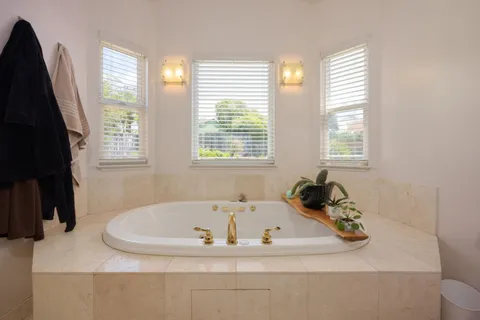 a white bath tub sitting in a bathroom next to a window