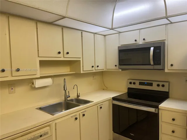 a kitchen with stainless steel appliances granite countertop a sink a stove and a microwave