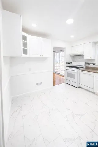 a large white kitchen with cabinets