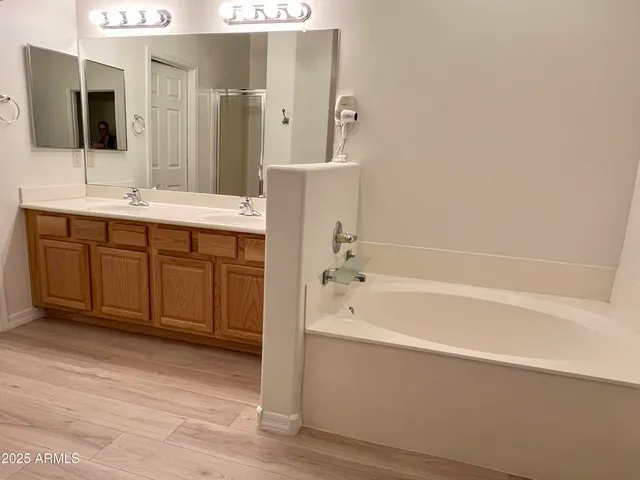 a bathroom with a tub sink and mirror