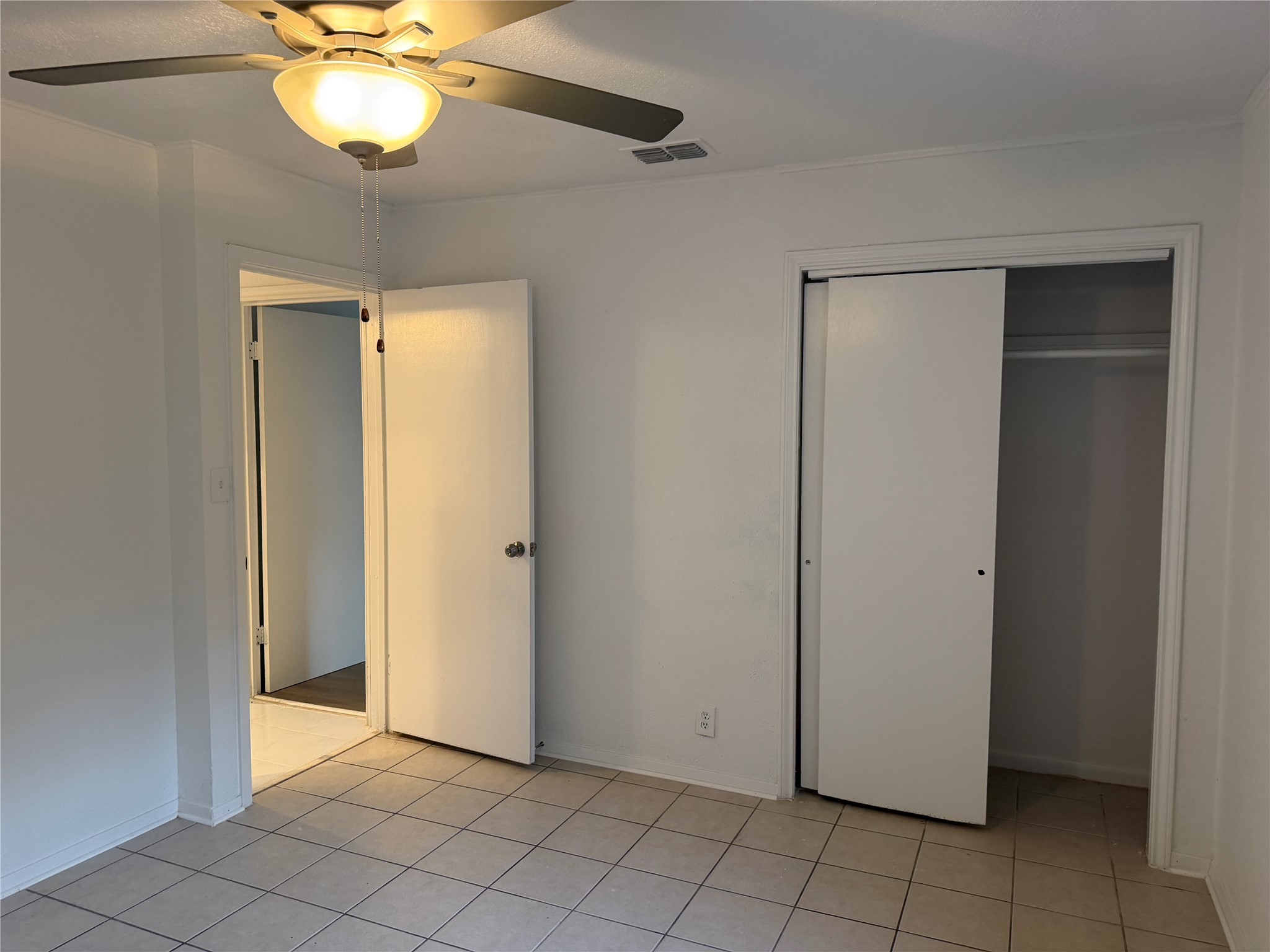 1060 Gardner Road Austin, TX 78721 - Photo 18 of 19 Functional bedroom featuring tile flooring and convenient sliding closet doors.