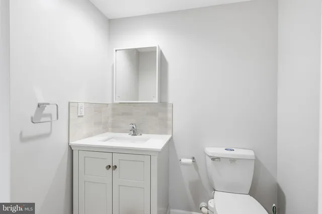 a bathroom with a toilet sink and mirror