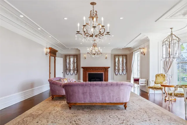 a living room with furniture a chandelier and a fireplace