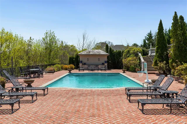 a swimming pool with outdoor seating and yard