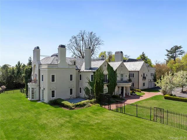 a view of a house with a big yard potted plants and large tree