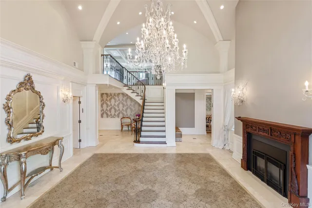 a view of a livingroom with a fireplace a chandelier and a couch