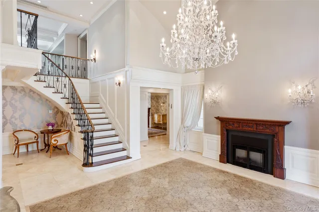 a view of a livingroom with a fireplace a chandelier and stairs