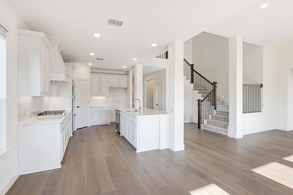 2401 Rileigh Lane Mansfield, TX 76063 - Photo 14 of 40 a large white kitchen with white cabinets and stainless steel appliances