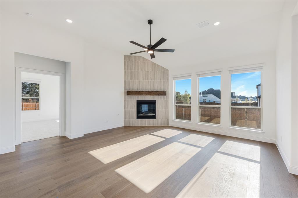 2401 Rileigh Lane Mansfield, TX 76063 - Photo 18 of 40 a view of an empty room with wooden floor fireplace and a window