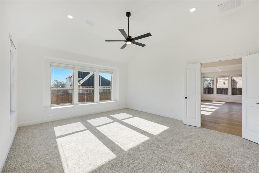 2401 Rileigh Lane Mansfield, TX 76063 - Photo 19 of 40 an empty room with chandelier fan and windows