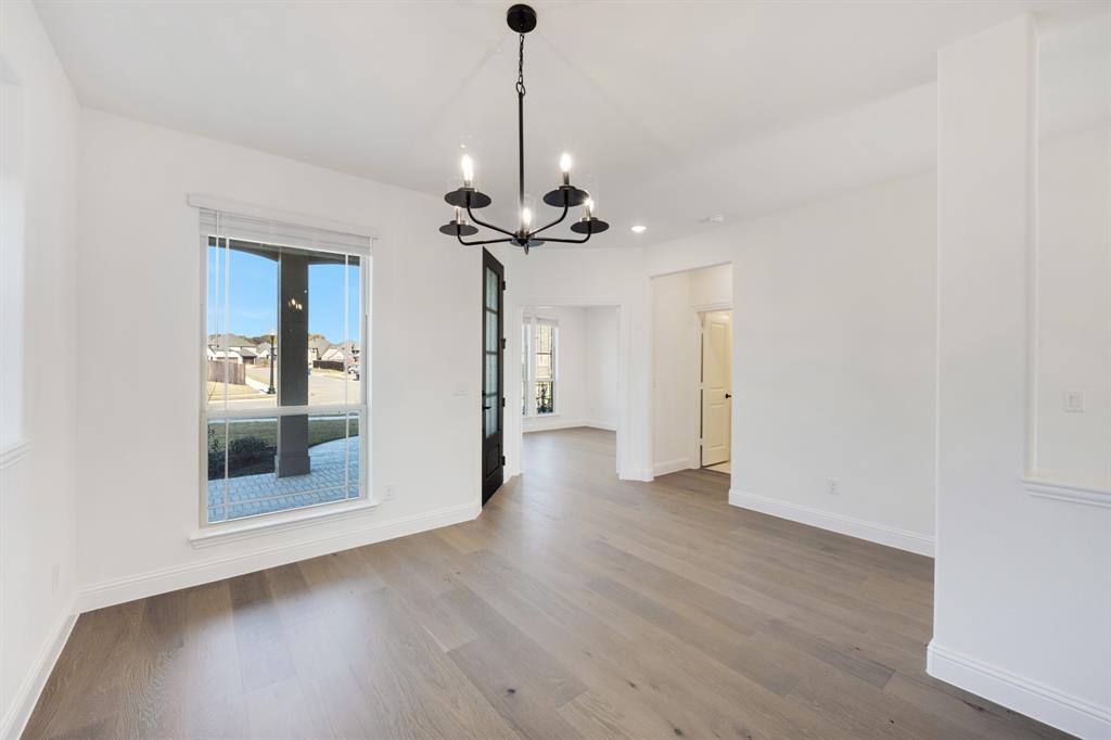 2401 Rileigh Lane Mansfield, TX 76063 - Photo 4 of 40 a view of a big room with wooden floor a ceiling fan and windows