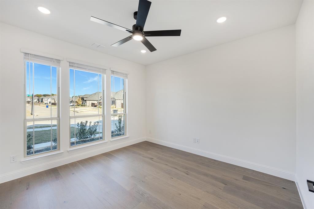 2401 Rileigh Lane Mansfield, TX 76063 - Photo 7 of 40 an empty room with wooden floor fan and windows