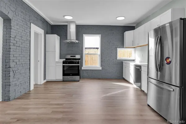 a kitchen with stainless steel appliances a refrigerator and a stove top oven