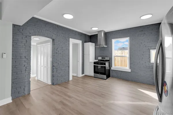 a view of empty room with a kitchen and windows