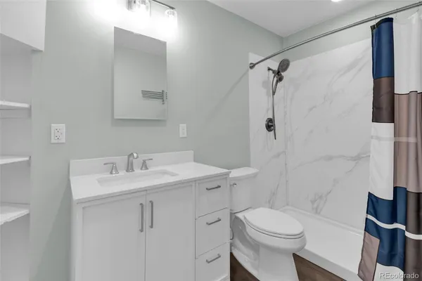 a bathroom with a sink toilet vanity and shower