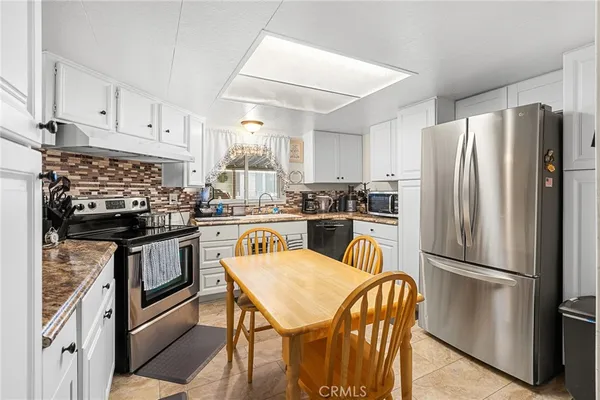 a room with a table chairs and a kitchen view