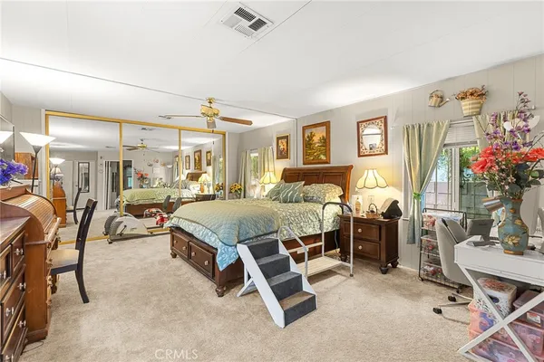 a spacious bedroom with a bed dresser and a window