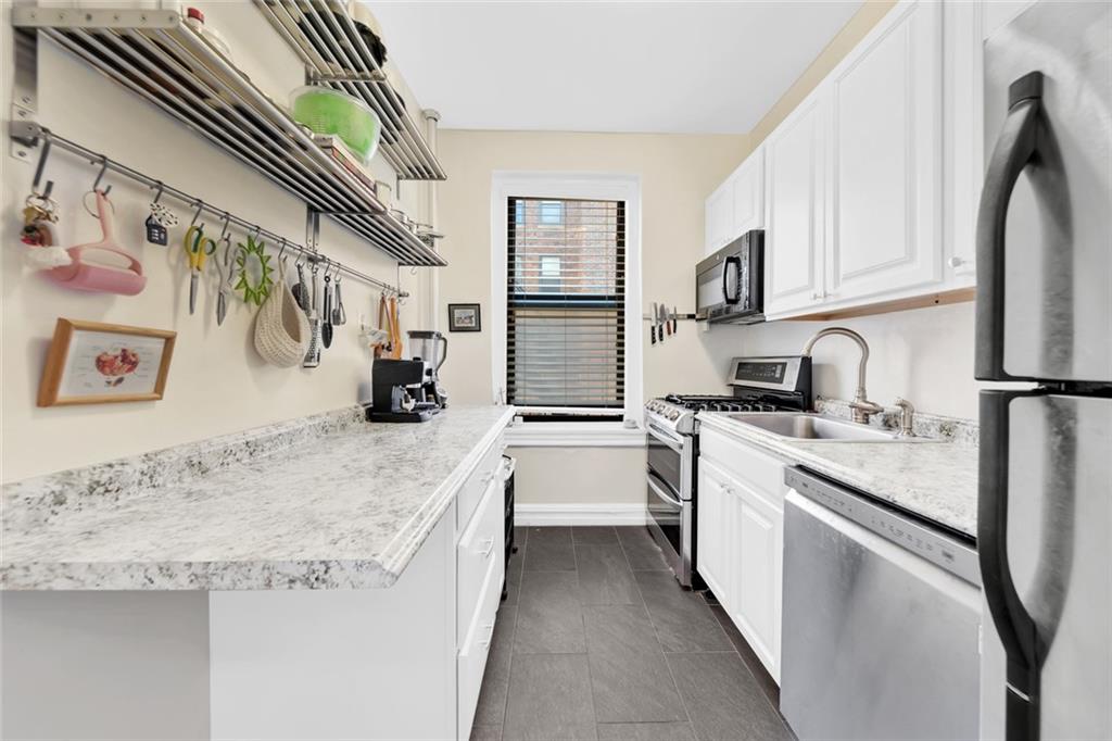 255 79th Street, Unit D8 Brooklyn, NY 11209 - Photo 3 of 8 a kitchen with stainless steel appliances granite countertop a sink stove and refrigerator