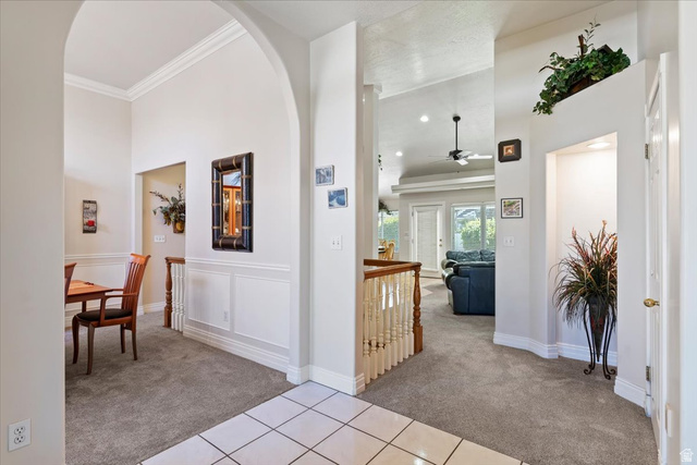 1924 North 2000th Street East Layton, UT 84040 - Photo 5 of 41 Hallway with light colored carpet, arched walkways, and light tile patterned floors
