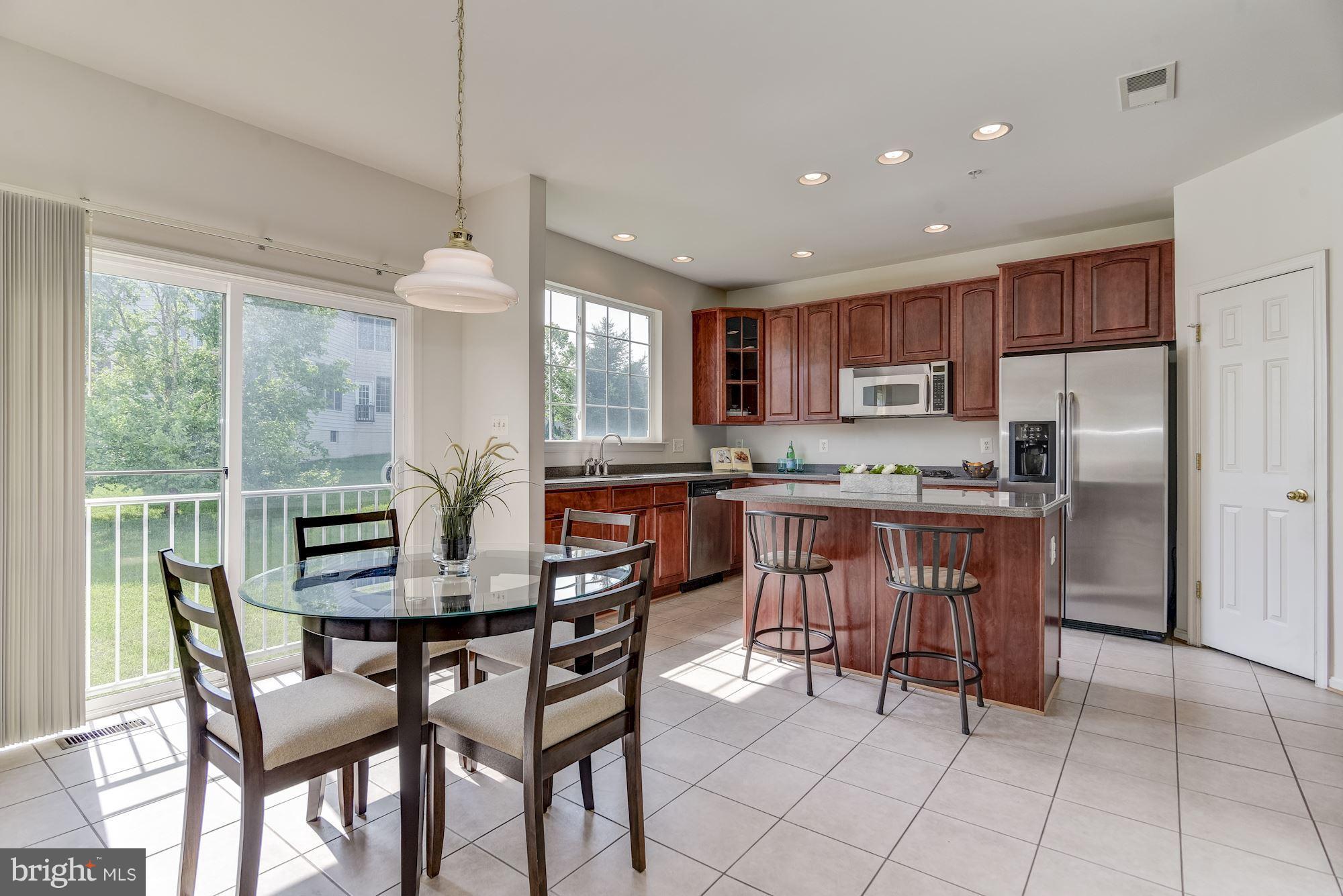 14629 Bubbling Spring Road Boyds, MD 20841 - Photo 11 of 30 a kitchen with a table chairs refrigerator and cabinets