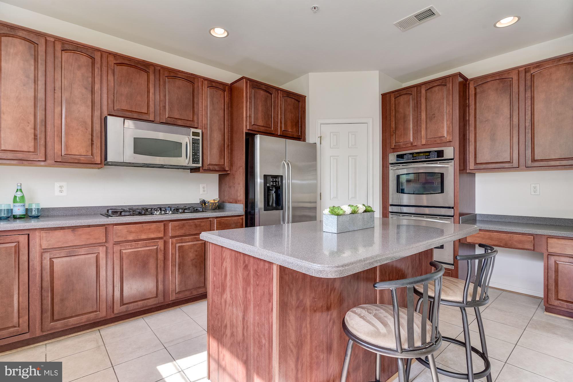 14629 Bubbling Spring Road Boyds, MD 20841 - Photo 9 of 30 a kitchen with stainless steel appliances granite countertop a stove a sink dishwasher a microwave oven with granite countertops and cabinets