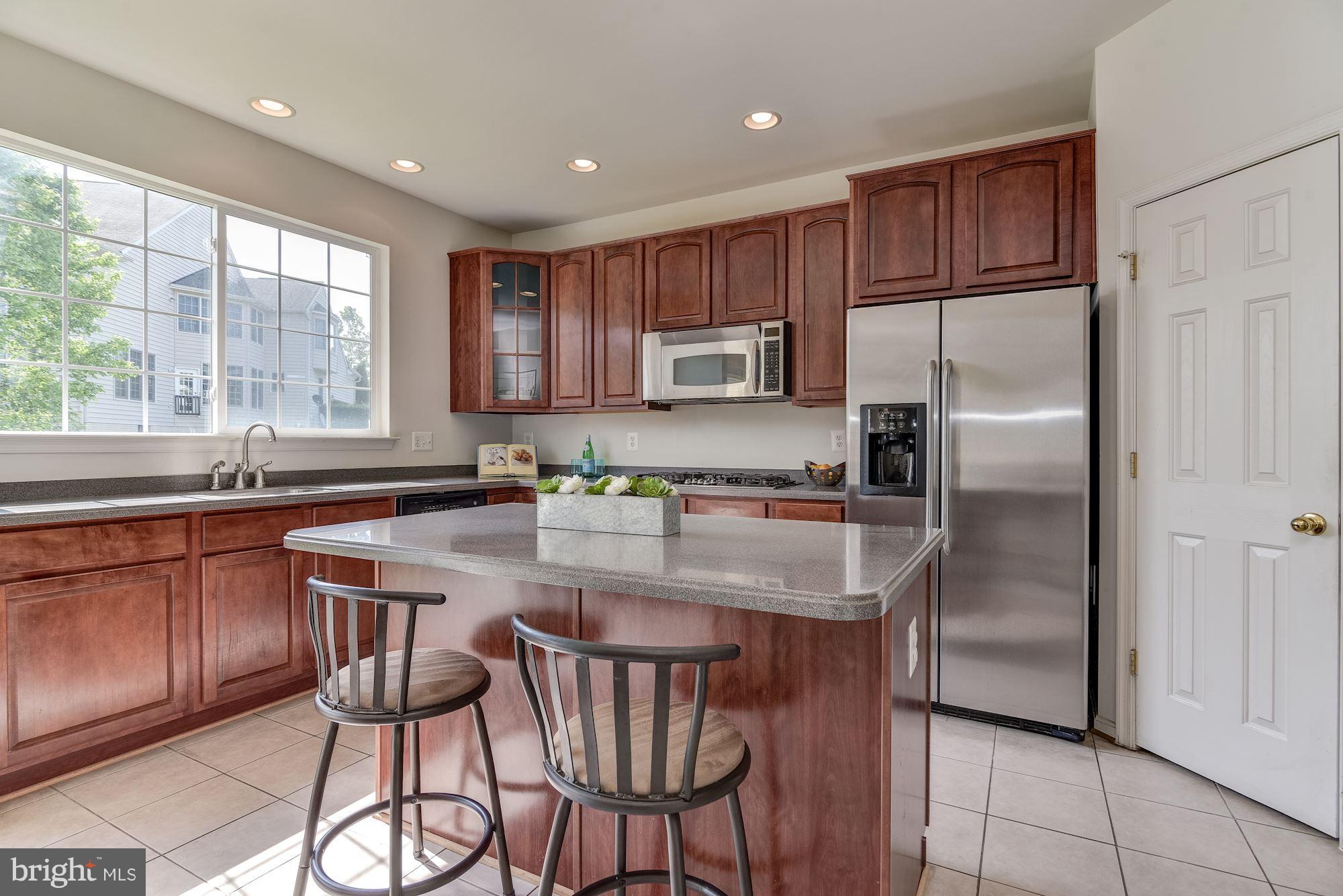 14629 Bubbling Spring Road Boyds, MD 20841 - Photo 10 of 30 a kitchen with stainless steel appliances granite countertop a stove a refrigerator a sink a dining table and chairs