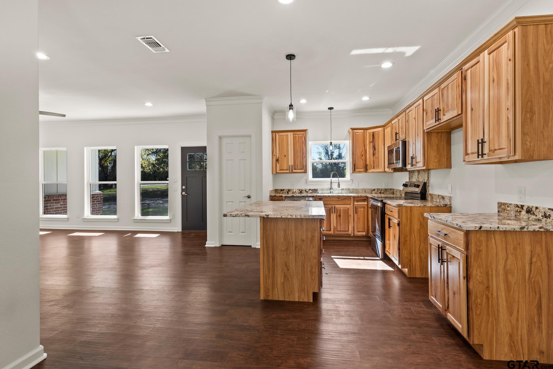 1339 Hwy 67 Mount Mount Vernon, TX 75457 - Photo 17 of 47 a kitchen with stainless steel appliances kitchen island granite countertop wooden floors and white cabinets