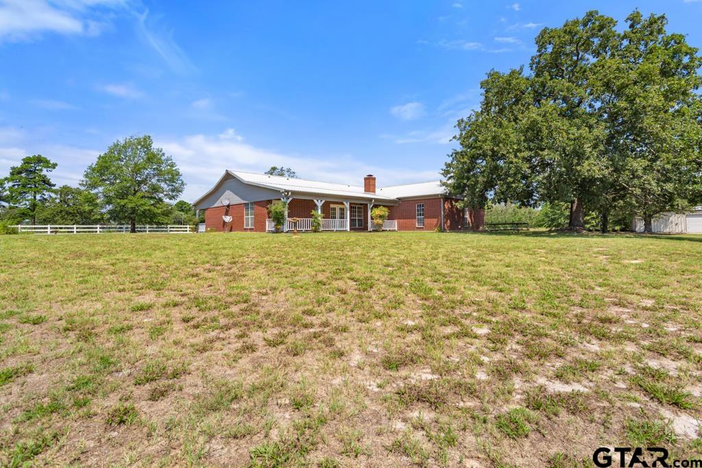 14762 County Road 3147 Tyler, TX 75706 - Photo 25 of 48 a view of a large pool with lawn chairs under an umbrella