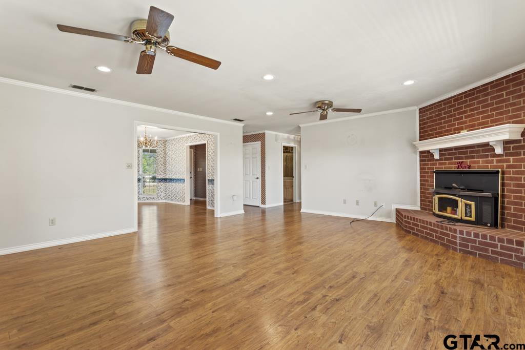 14762 County Road 3147 Tyler, TX 75706 - Photo 6 of 48 a view of a livingroom with a fireplace a ceiling fan and wooden floor