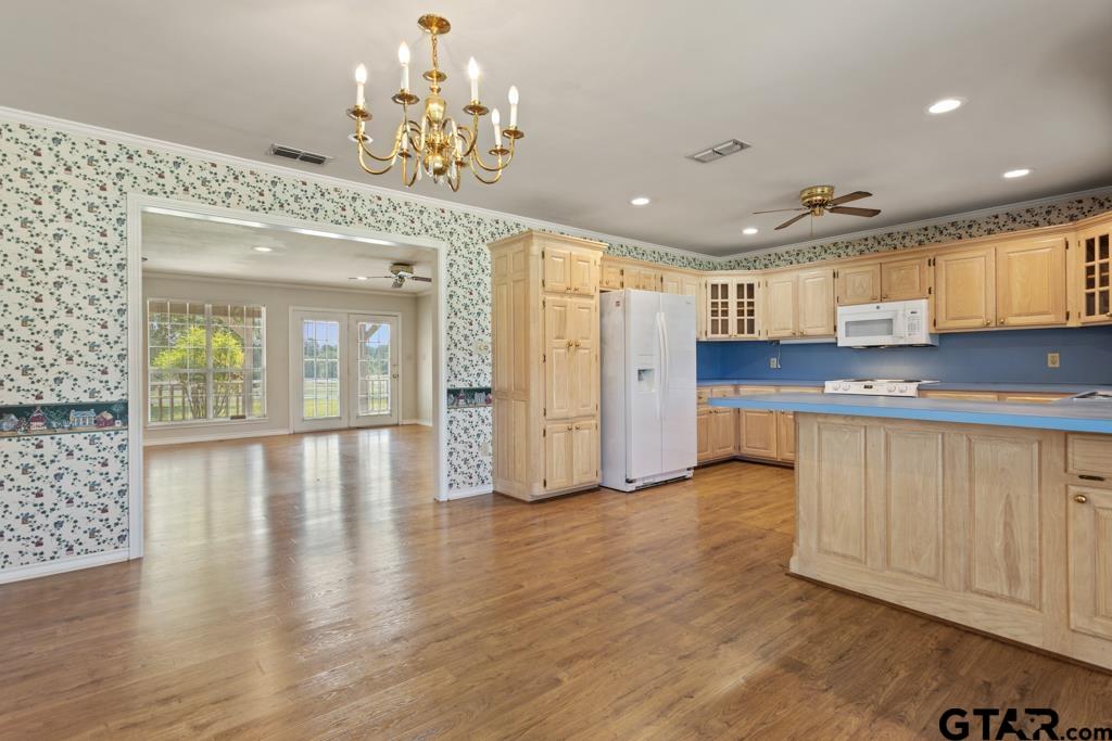 14762 County Road 3147 Tyler, TX 75706 - Photo 9 of 48 a view of kitchen with stainless steel appliances granite countertop a stove top oven a sink and white cabinets with wooden floor