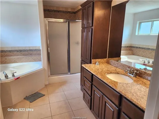 a bathroom with a granite countertop sink a mirror and shower