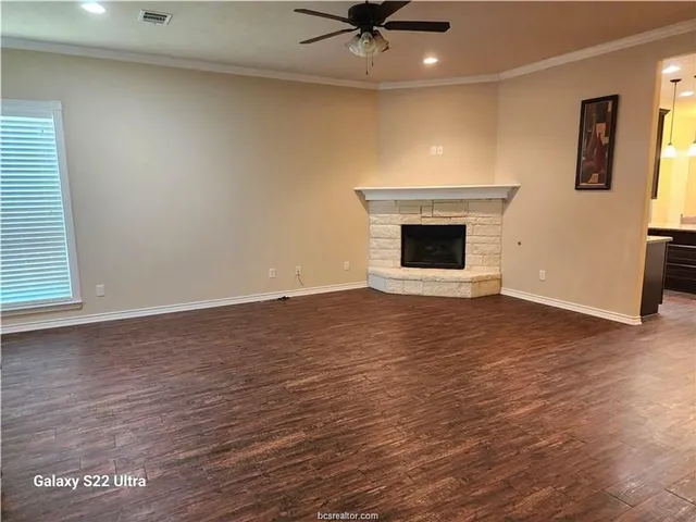 a view of an empty room with a fireplace and a window