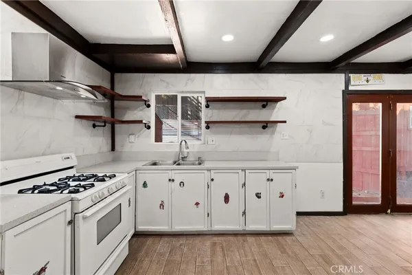 a kitchen with granite countertop a stove and a wooden floors