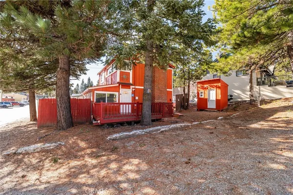 a backyard of a house with barbeque oven and trees