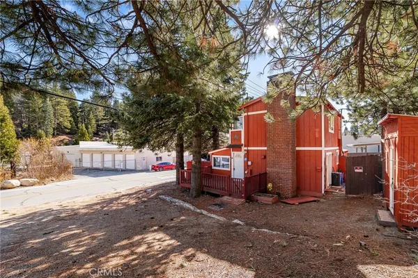a backyard of a house with barbeque oven and a tree