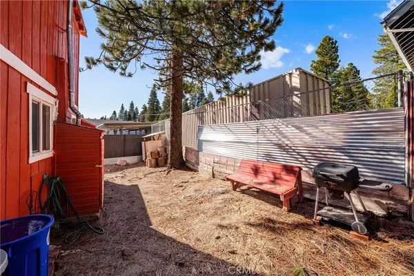 a view of a backyard with parking space and wooden fence