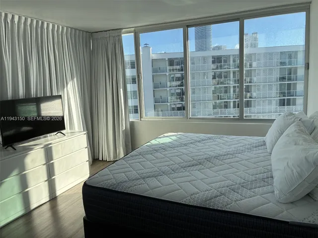 a bedroom with a bed and a large window