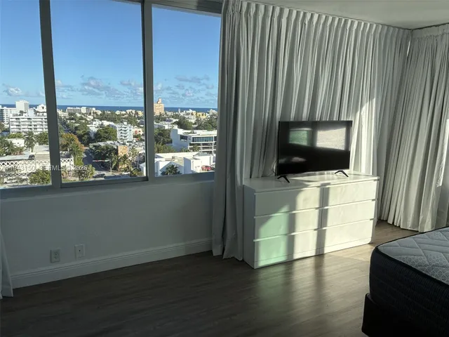 a view of a living room with hardwood floor and a flat screen tv